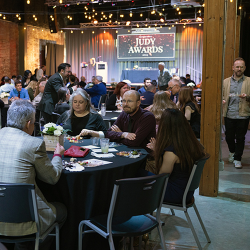 Crowd dines at tables in banquet hall