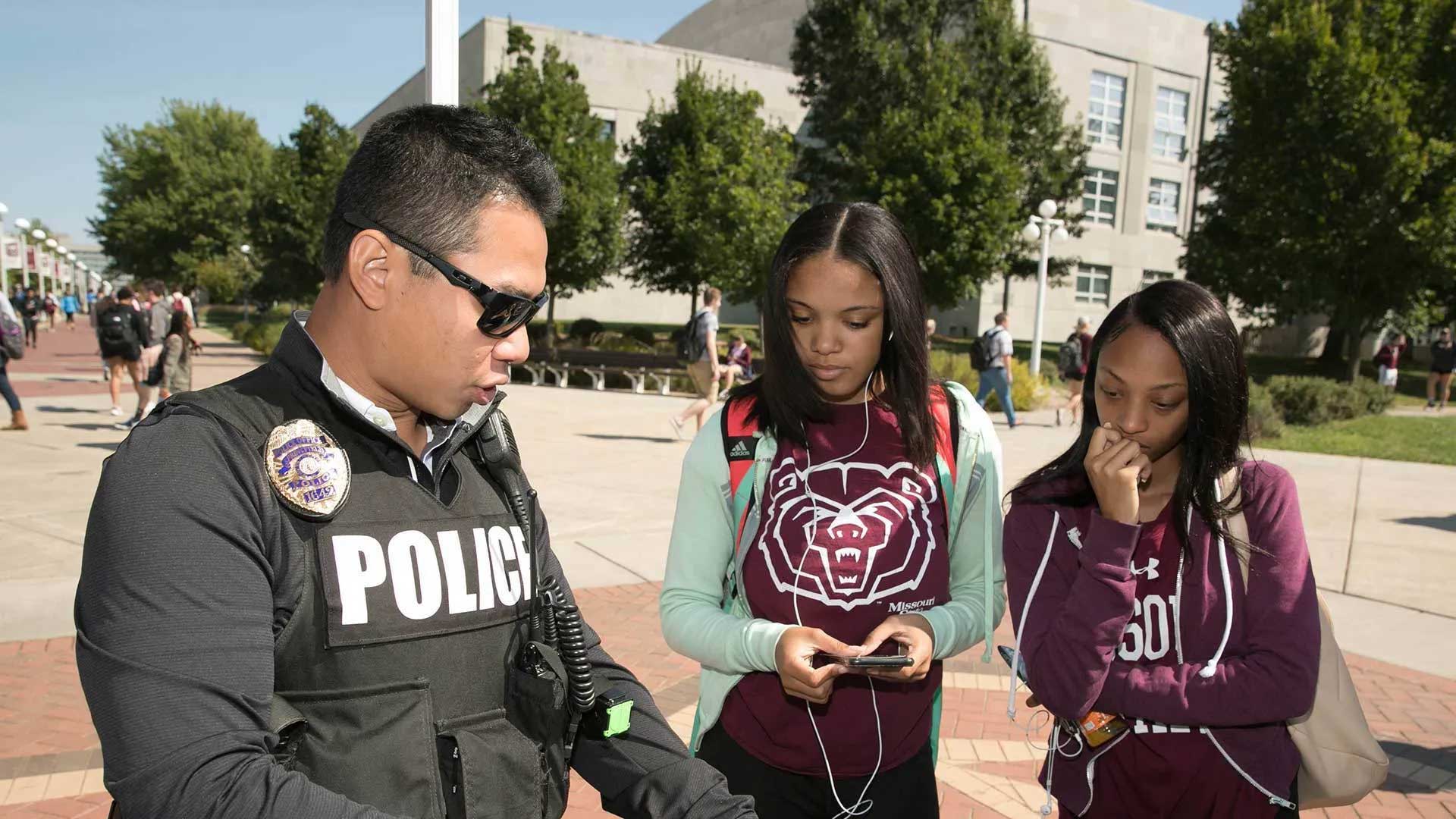 Police officer visits on campus with two students