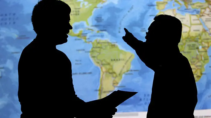 Professor points to map while talking to student