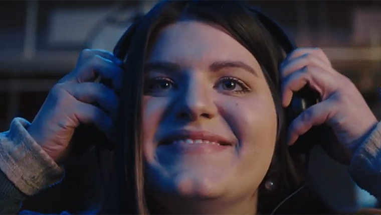 Student smiles wearing headphones